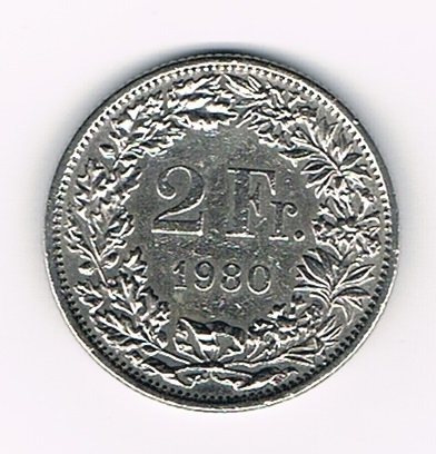 Pièce de 2 Francs argent Suisse émise en 1980 tranche striée. Descriptif. Helvetia, le personnage allégorique féminin suisse, vêtue d'une toge, tient une lance.