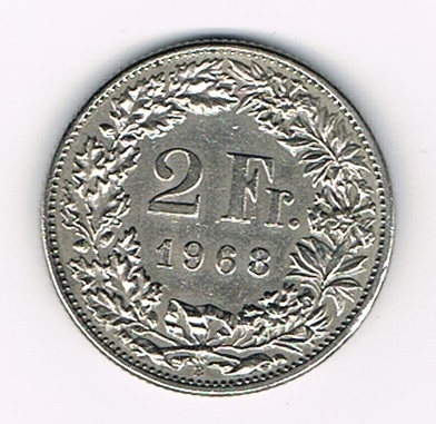 Pièce de 2 Francs argent Suisse émise en 1968 tranche striée. Descriptif. Helvetia, le personnage allégorique féminin suisse, vêtue d'une toge, tient une lance.